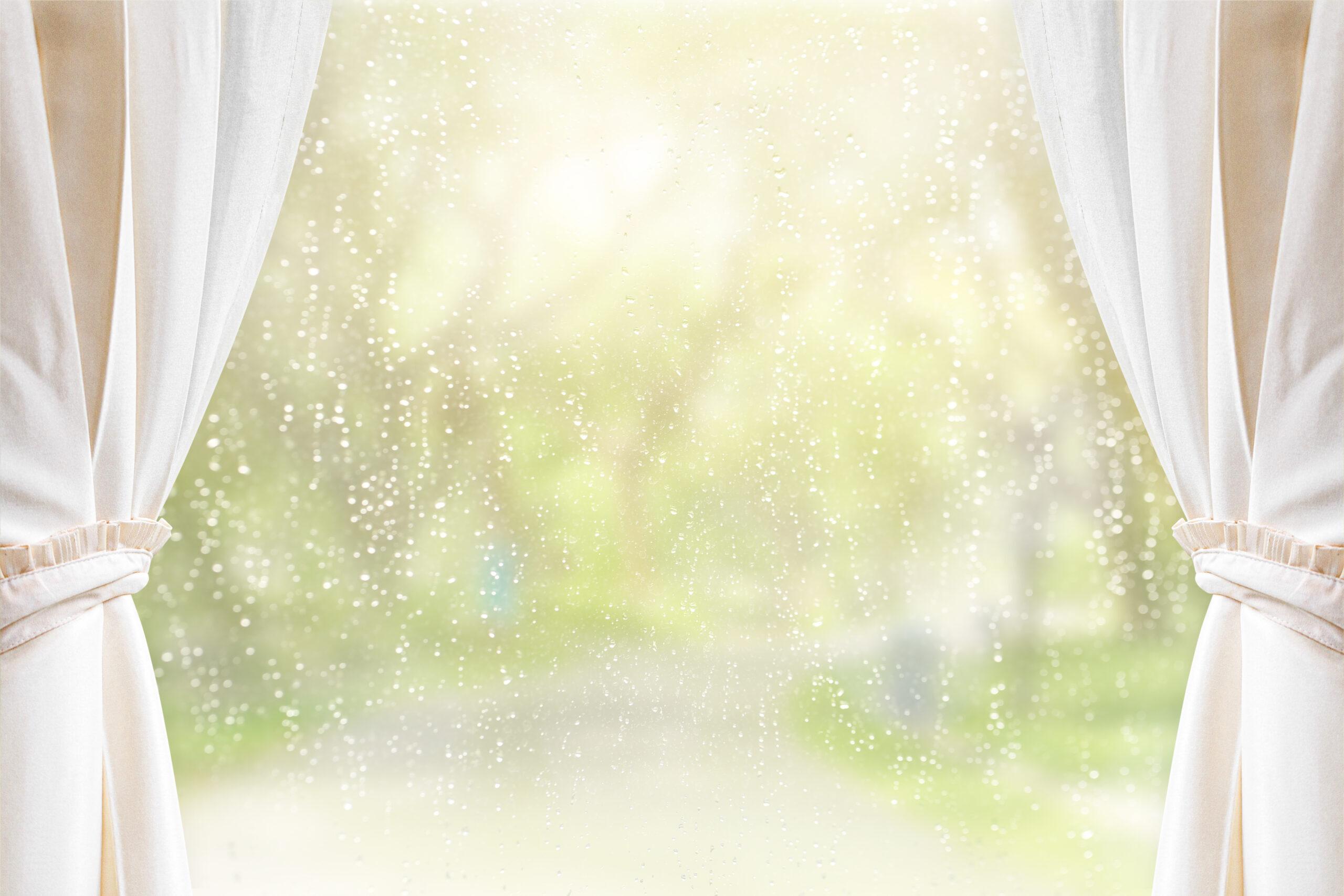 Cream curtains on window glass with raindrops after summer rain. Can be used for display or montage your products