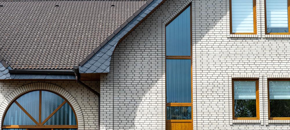 The church has a classic facade of white brick and a conical roof, visible semicircular and rectangular window.