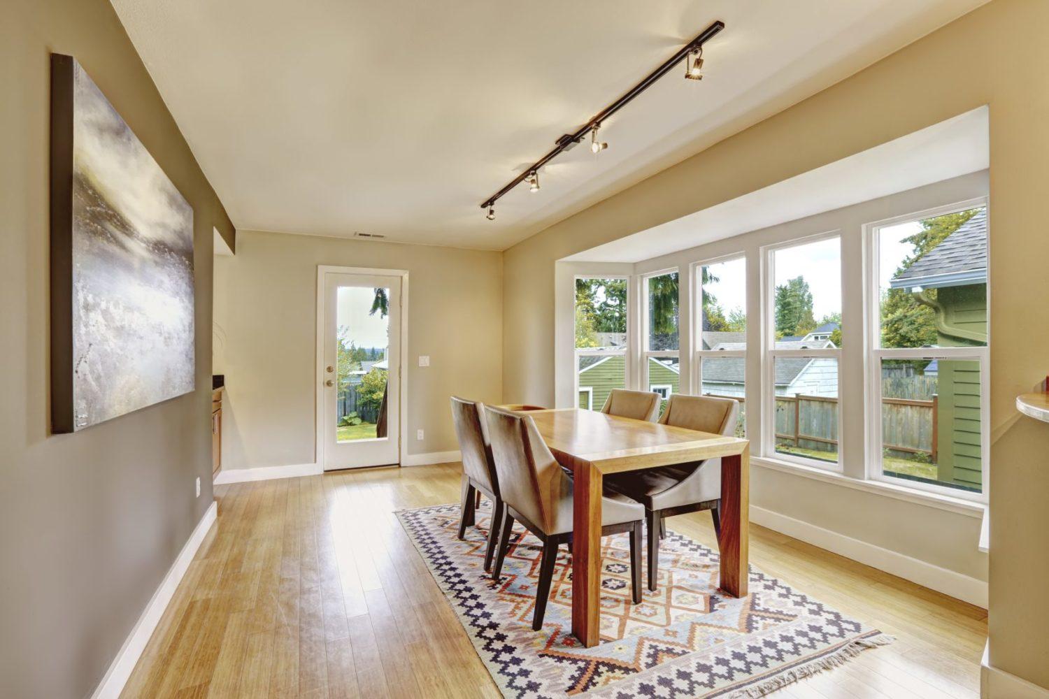 Cozy creamy tones dining room with wooden table set.